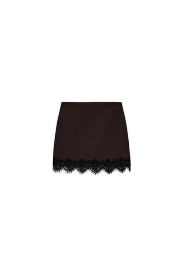 Front view of brown culottes with black lace trim, a fitted cut and a high waist. Side fastening with a concealed zip.