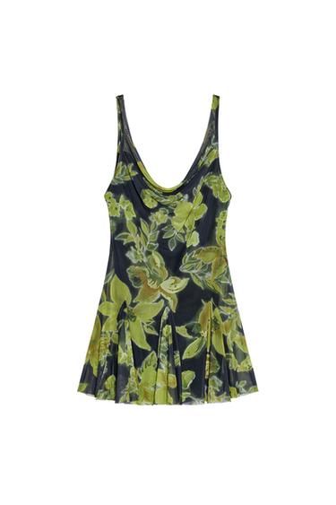 Front view of a dress with a green and black floral print, cowl neckline, and pleated skirt.