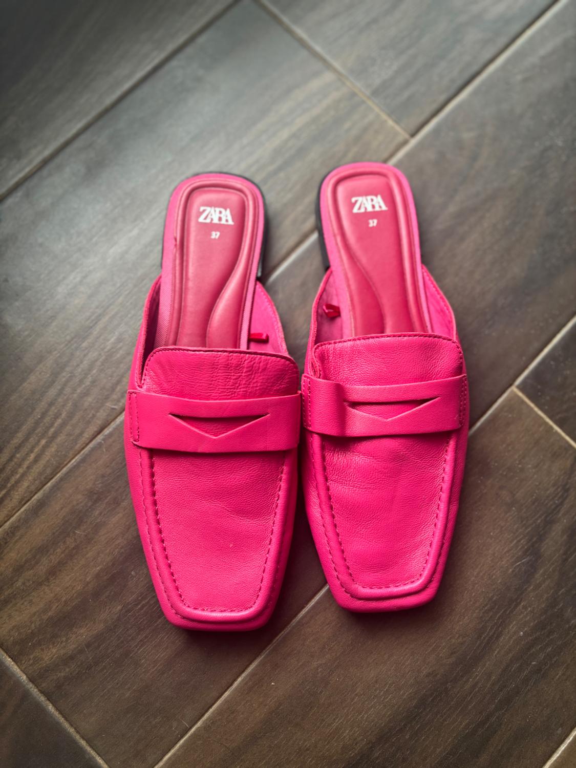 Fuchsia flat shoes with a square design and band detail, on a wooden floor. Visible text: "ZARA 37".