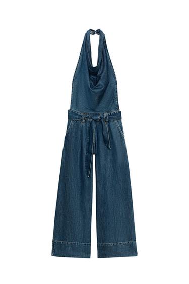 Front view of a blue playsuit with a halter neck, open back, matching belt, front pockets, and wide leg.