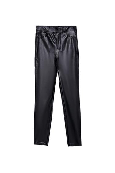Black slim-fit trousers with a shiny finish, front button, pockets and zip hems, on a white background.
