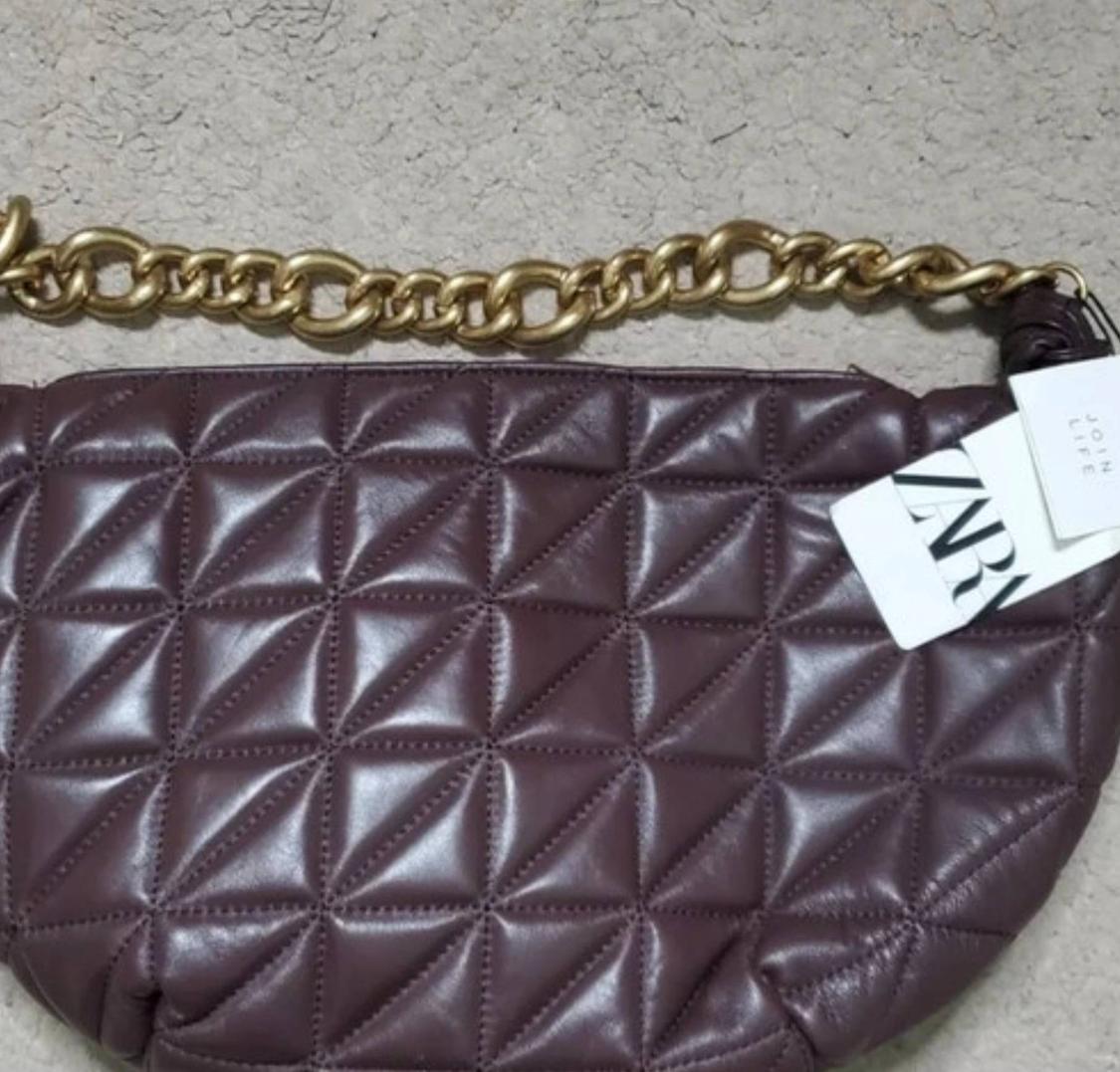 Burgundy bag with a quilted design and gold-tone chain against a light background. ZARA JOIN LIFE label.