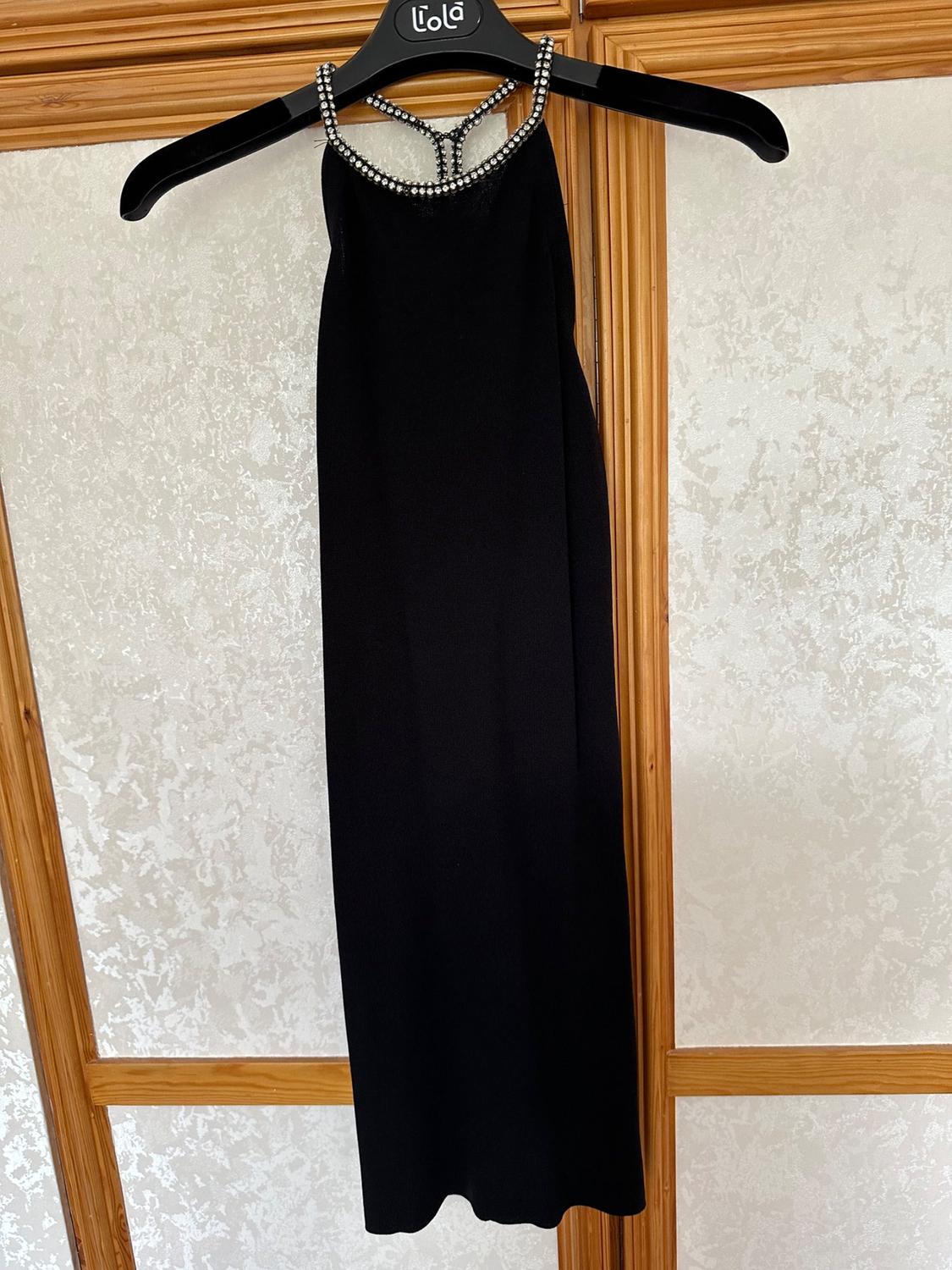 Front view of a black dress with a neckline adorned with beading.