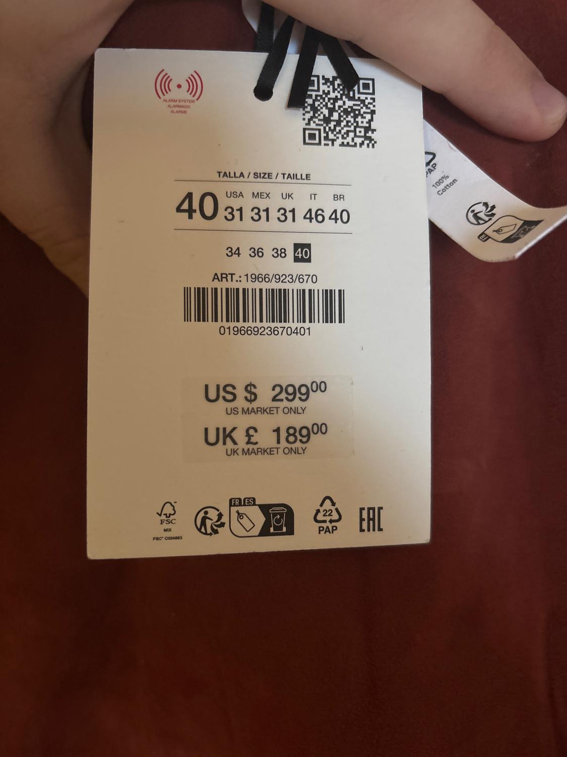Clothing label with sizes 40 and prices: US $299, UK £189. Includes QR code, barcode, and recycling symbols on a red background.