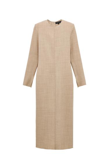 Front view of long beige dress with long sleeves and round neck.