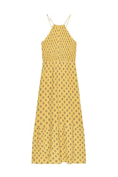 Front view of a yellow midi dress with geometric print, halter neck and thin straps crossed at the back.