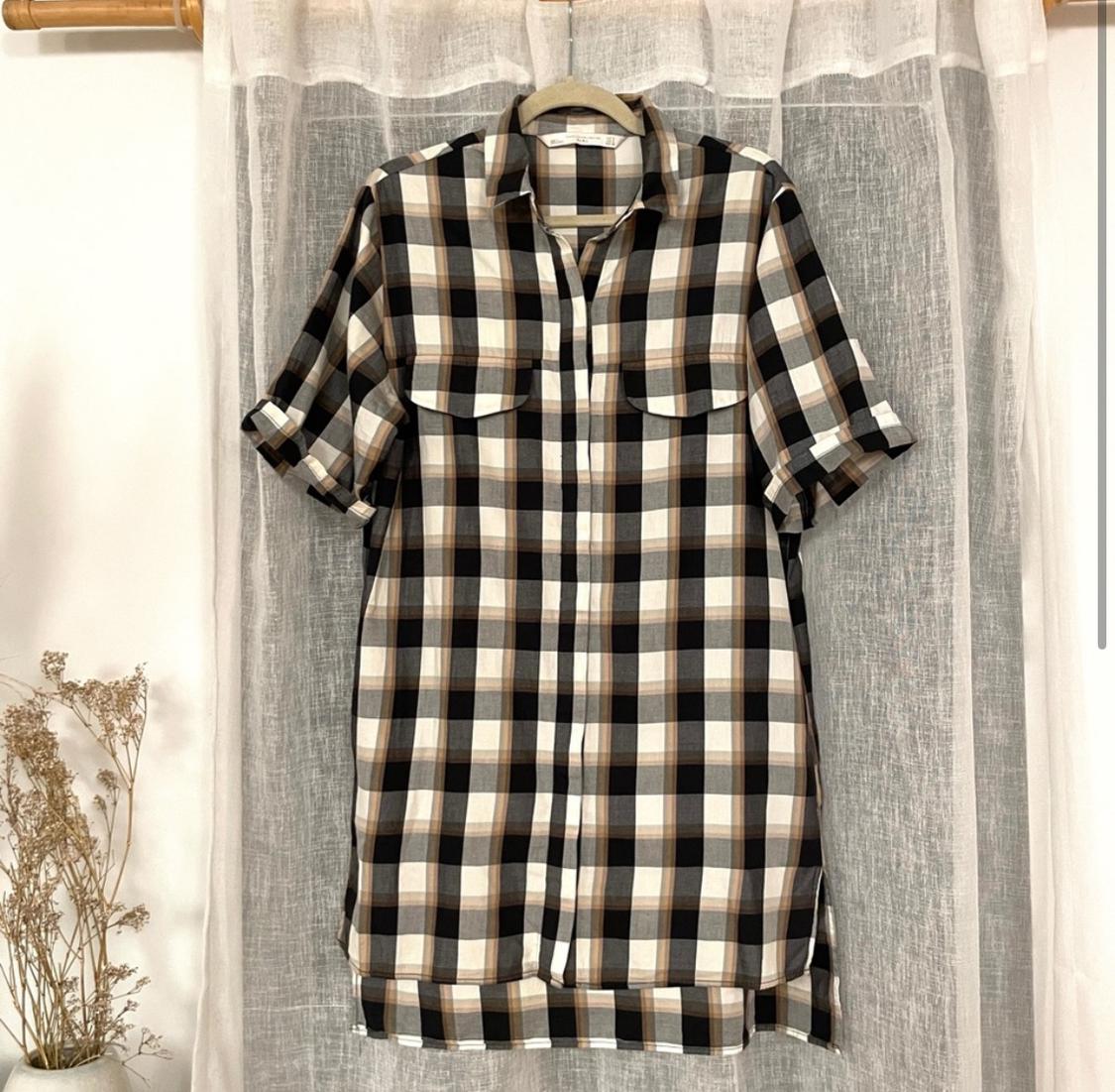 Front view of a plaid shirt with front pockets and short sleeves.
