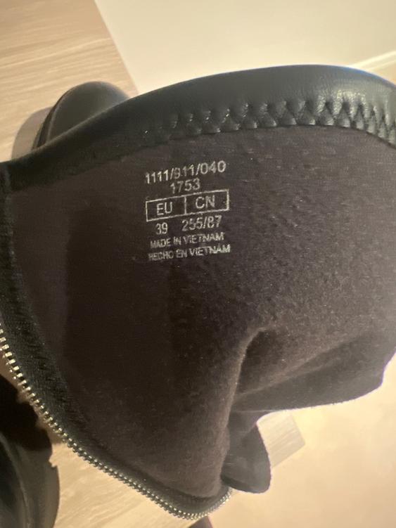 Inside label of a black boot with a zip, showing size 39 EU, 255/87 CN, made in Vietnam. Visible text: "MADE IN VIETNAM, HECHO EN VIETNAM".