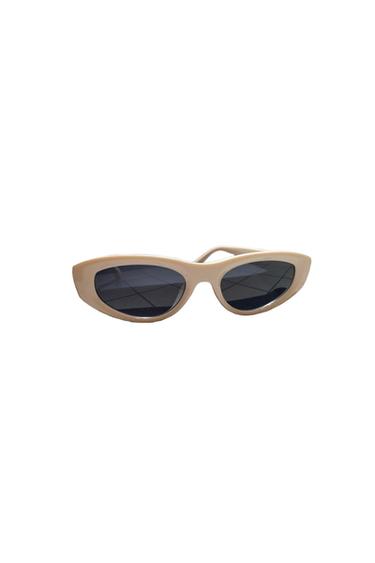 Beige-framed cat-eye sunglasses with dark lenses, on a white background.