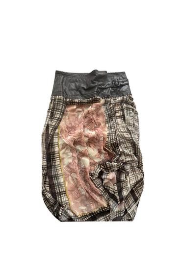 Skirt with black waist, brown plaid design, and a central floral panel in pink and beige. Creative and textured style.