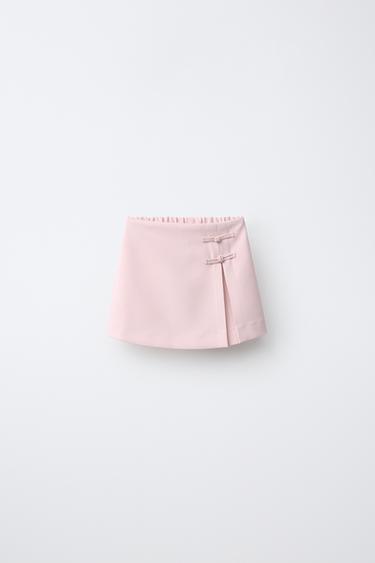 Pantalón corto con falda y cierre de botones