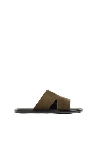 Side view of brown sandal with criss-cross straps.