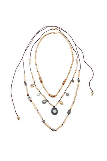 Pack of three gold-plated necklaces with cords and assorted charms, including stars and decorative pendants. Lobster clasps and tie fastenings.