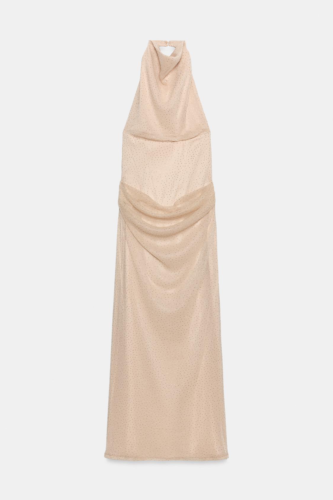 Front view of a beige sleeveless midi dress, featuring a halter neck, draped detailing at the waist and embellishment with sparkles.