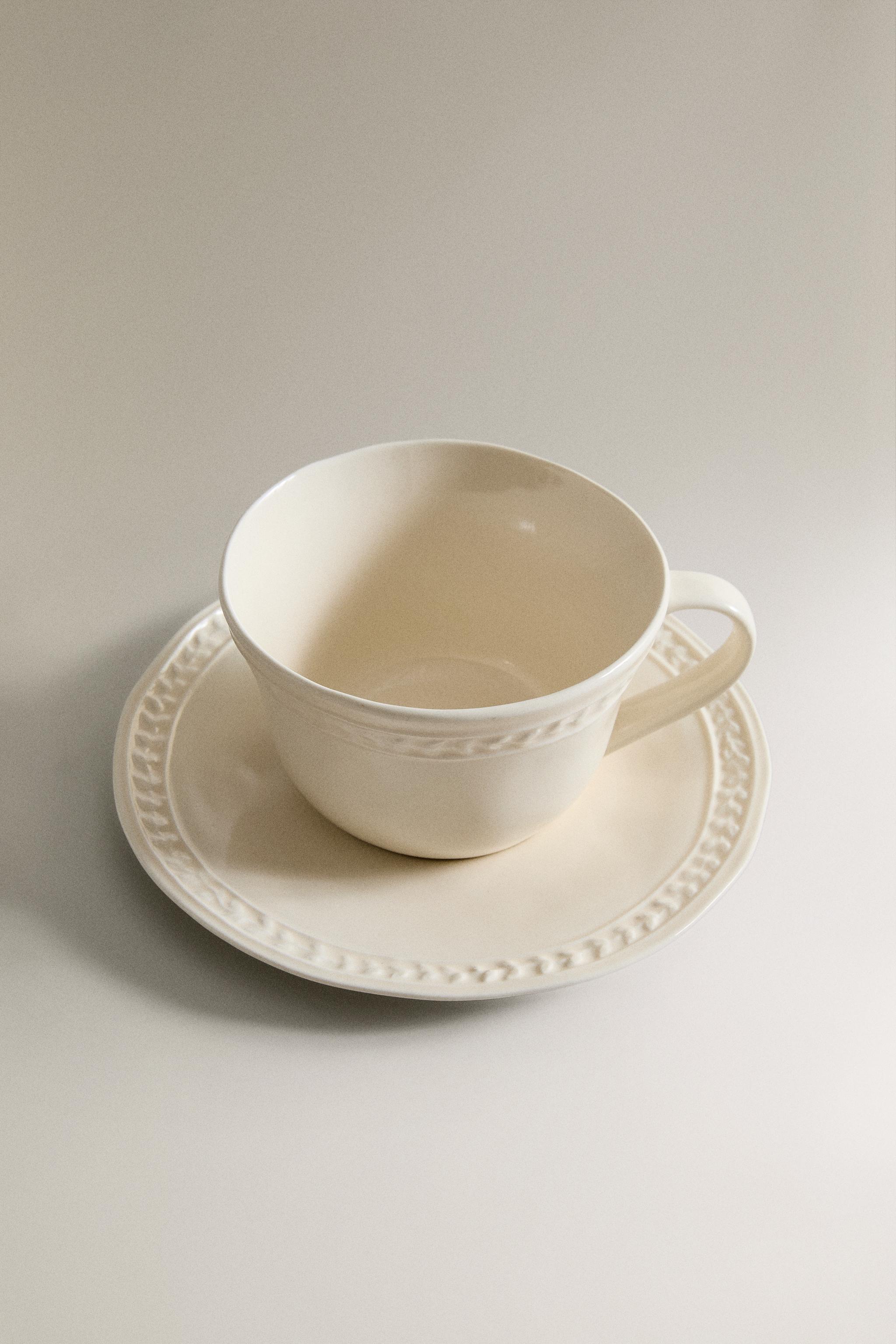 RAISED STONEWARE TEACUP AND SAUCER