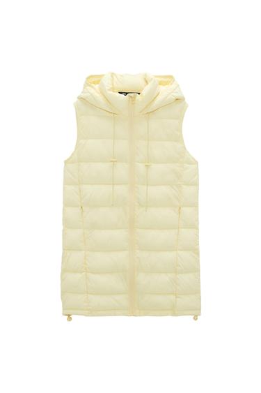 Front view of a light yellow padded gilet with a hood and zip.