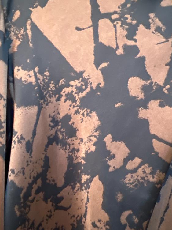 Fabric with an abstract print in brown and black tones, with irregular patterns that create a dynamic visual effect.