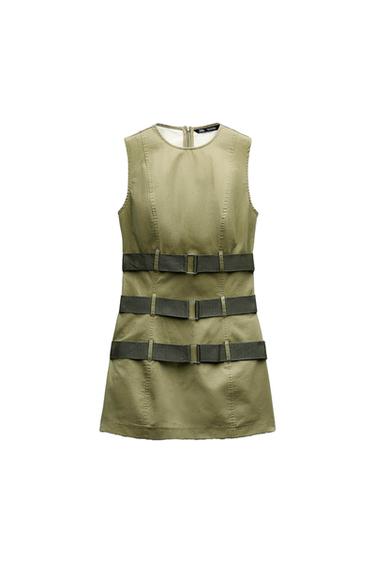 Sleeveless khaki dress with three dark horizontal belts on the front. White background.