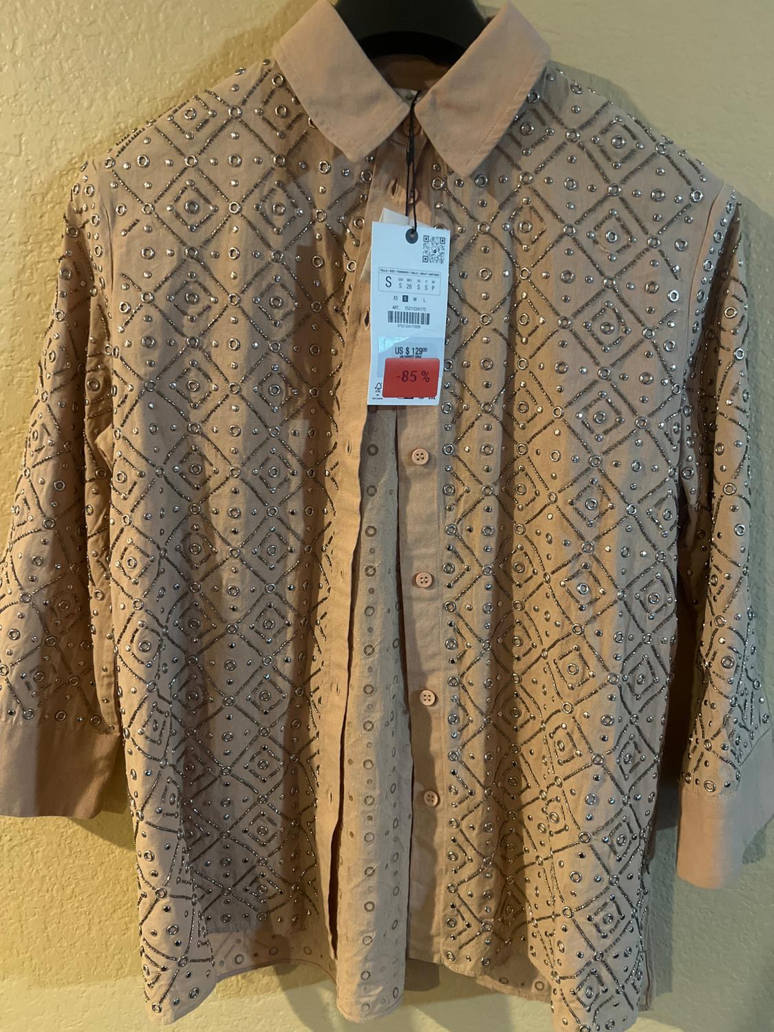 Beige shirt with geometric rhinestone design, classic collar and front buttons. Visible label with 85% discount.