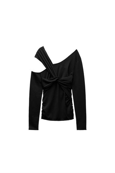 Front view of an asymmetrical black blouse with a knot and one shoulder exposed.