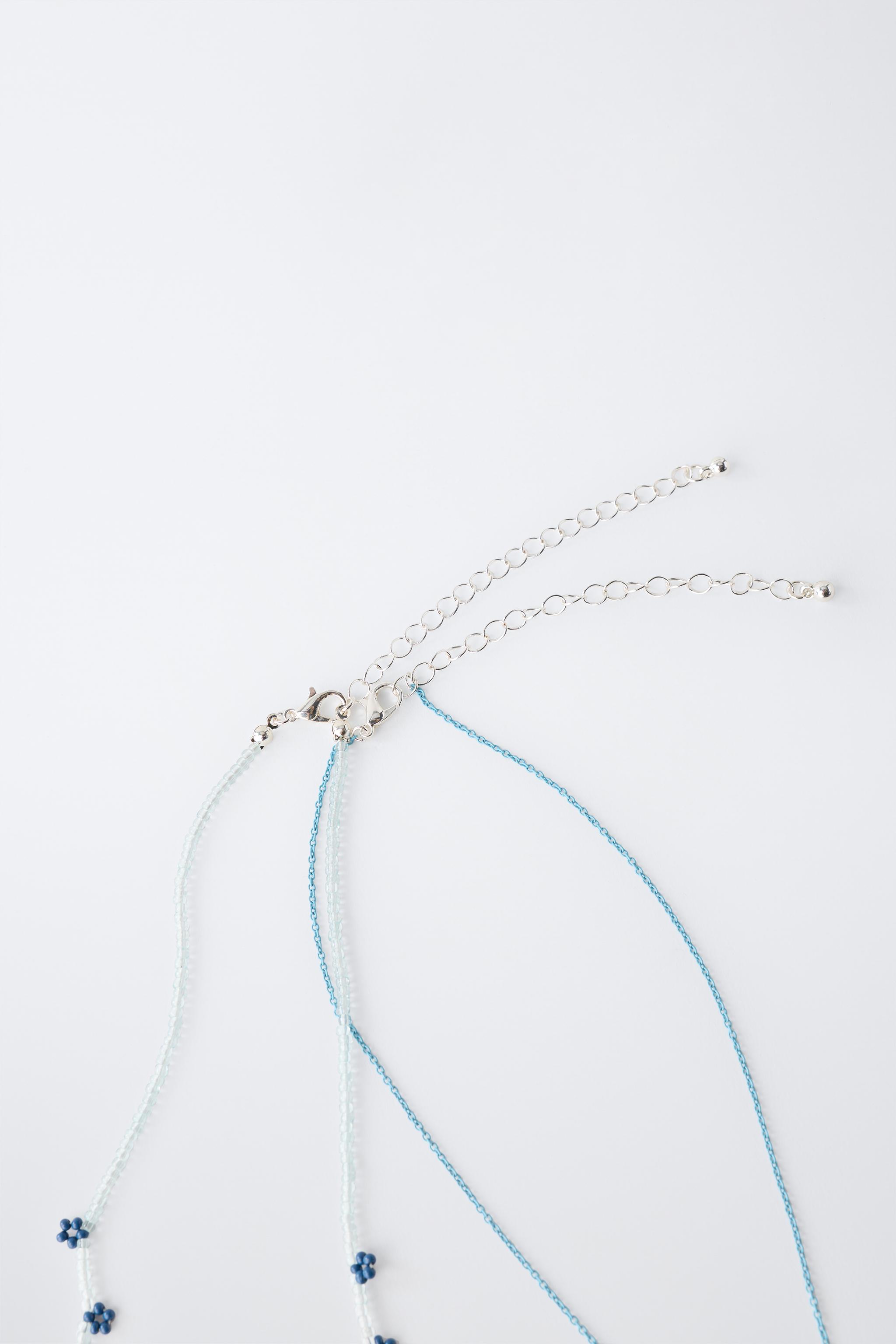 LOT DE DEUX COLLIERS FANTAISIE PAPILLON ET FLEURS