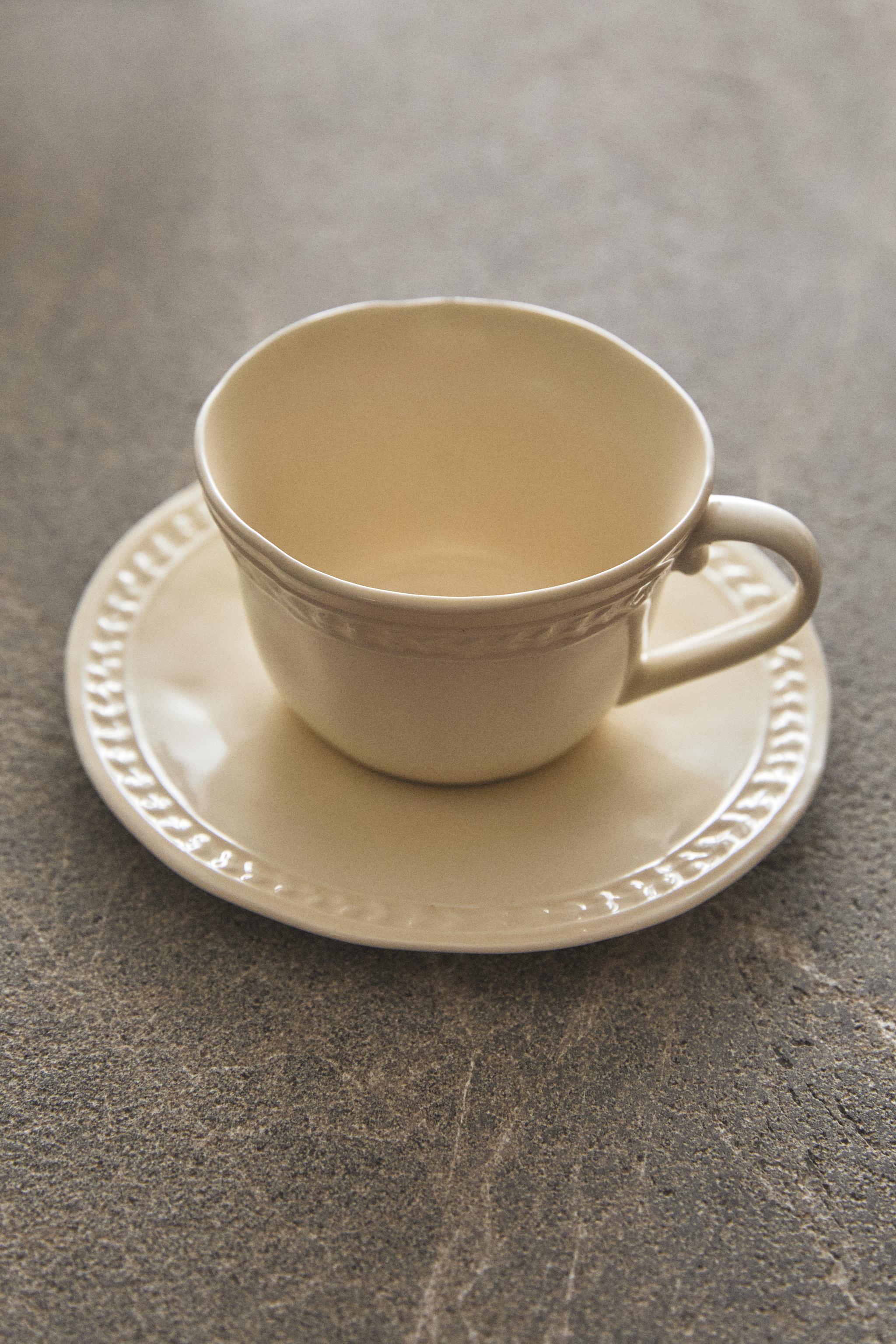 RAISED STONEWARE TEACUP AND SAUCER