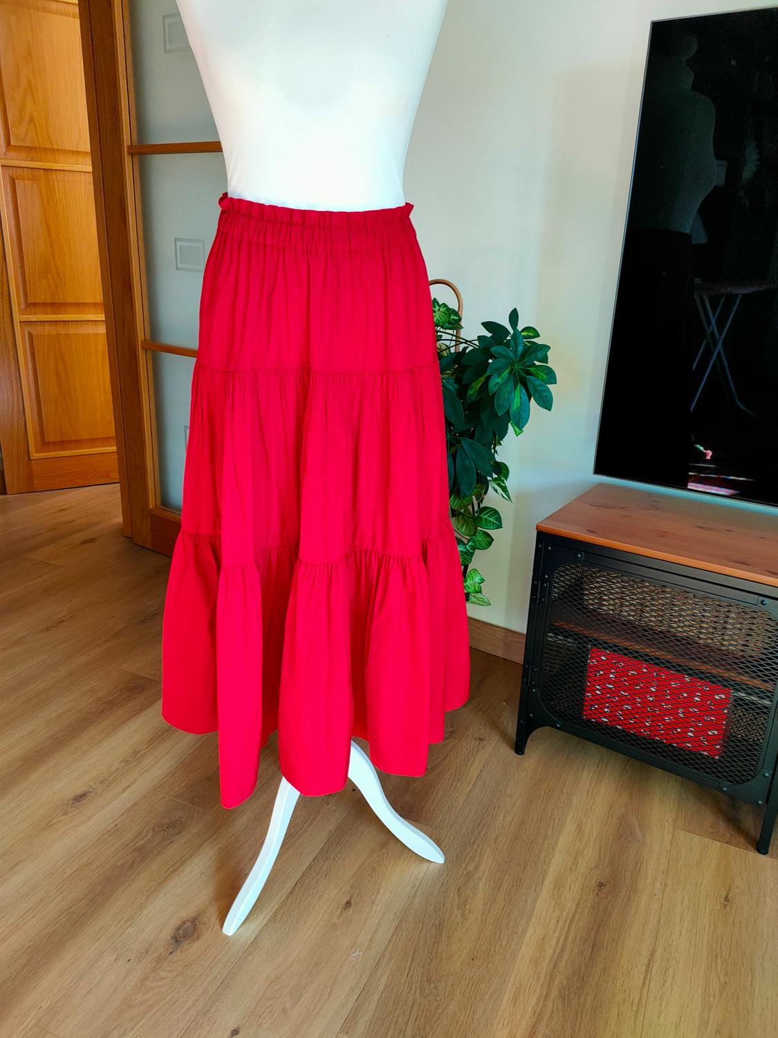 Midi-length red skirt set with elasticated waist and ruffles, on a mannequin.