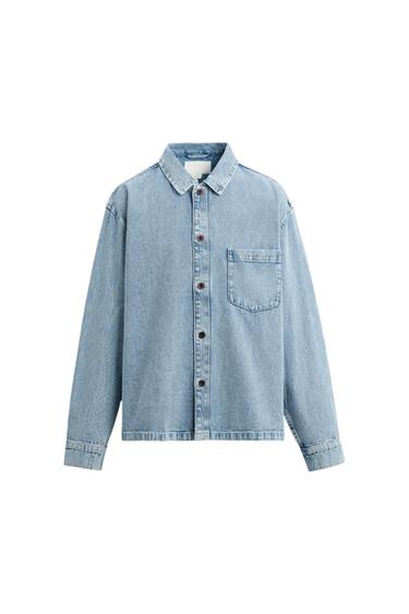 Light blue denim shirt with dark buttons and a chest pocket, on a white background.