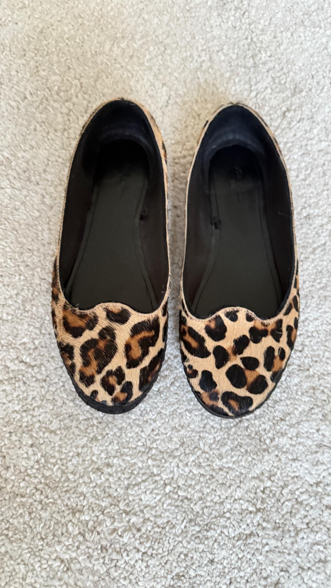 Leopard print flat shoes on a beige carpet. Top view, showing the complete shoe design.