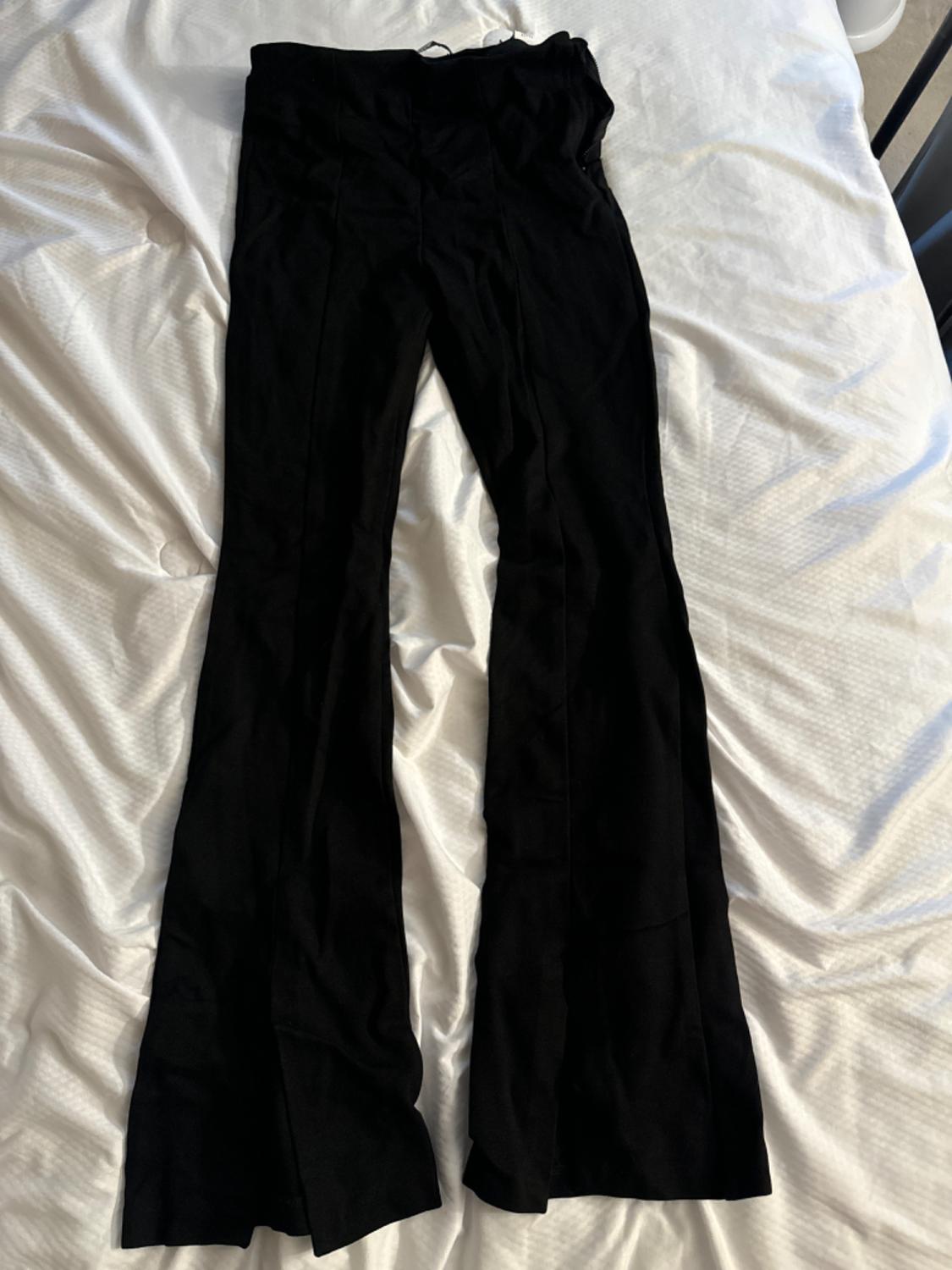 Front view of black flared trousers on a white background.