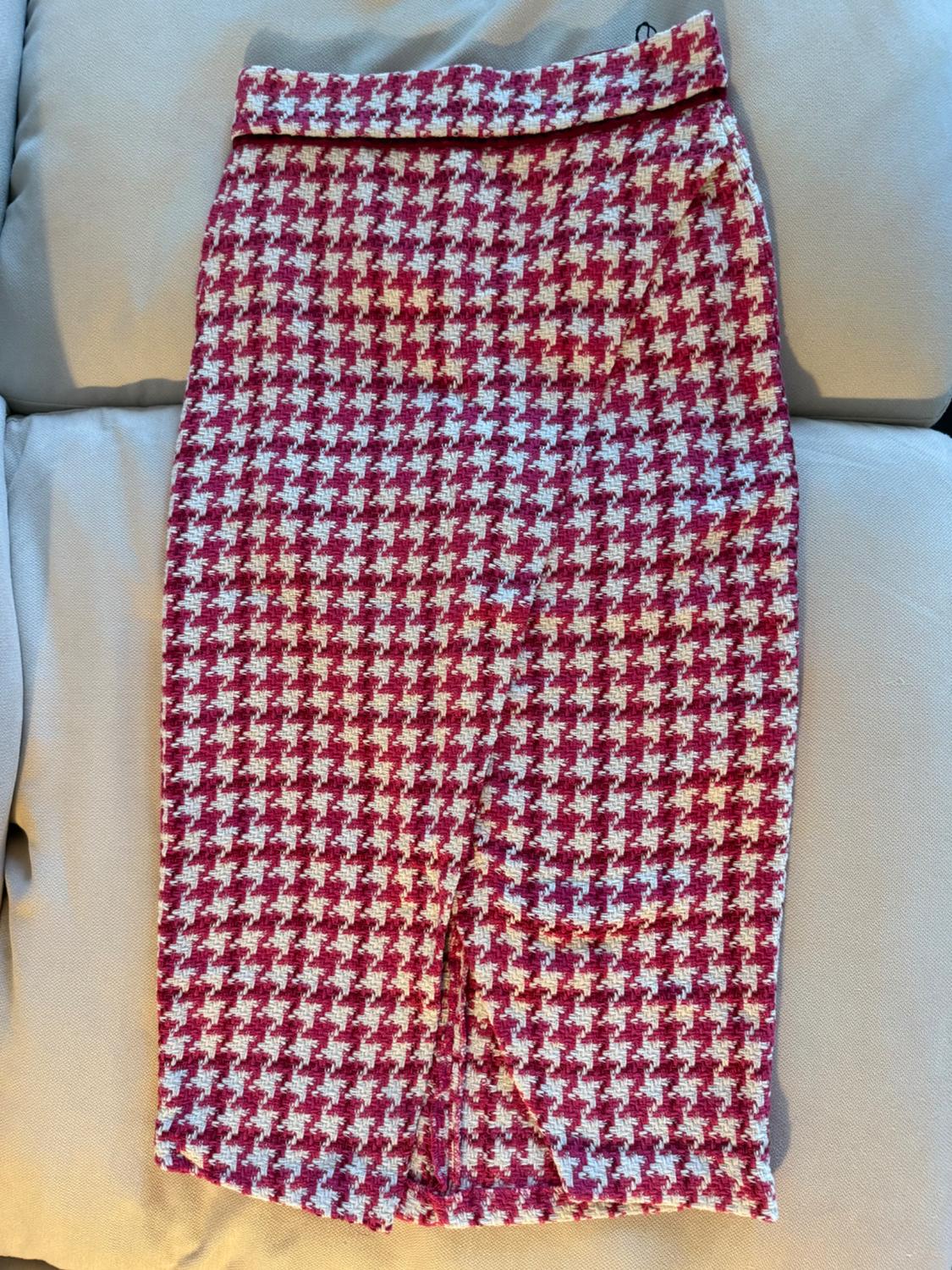 Red and white houndstooth print pencil skirt, on a quilted beige background.