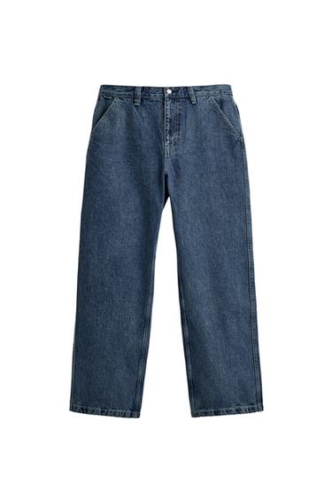 Front view of blue denim chino trousers with slanted front pockets, patch back pockets and zip and button fastening.