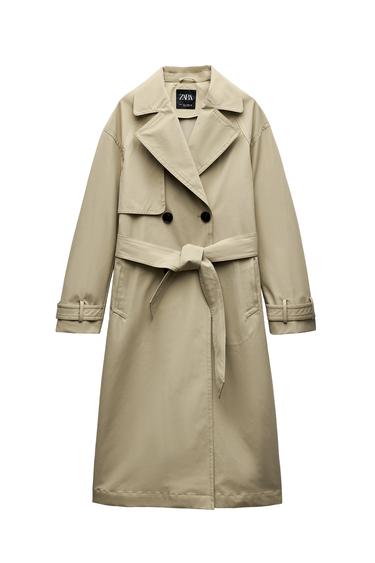Front view of a long beige coat with large lapels and a tied belt.