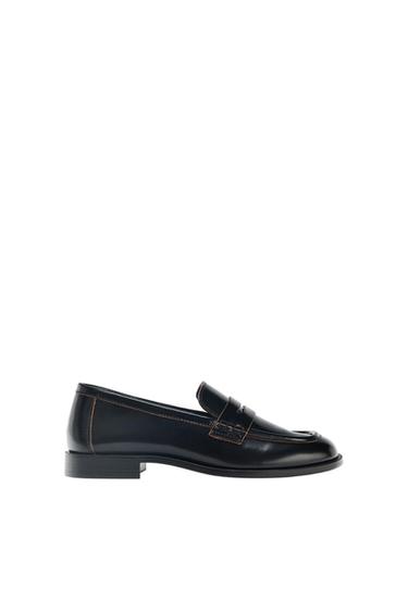 Classic black moccasin with brown contrast stitching, shown in profile on a white background.
