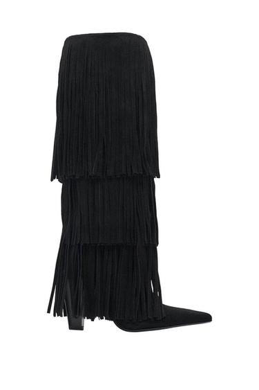 Black high-heeled boot with layered fringe, side view on white background.