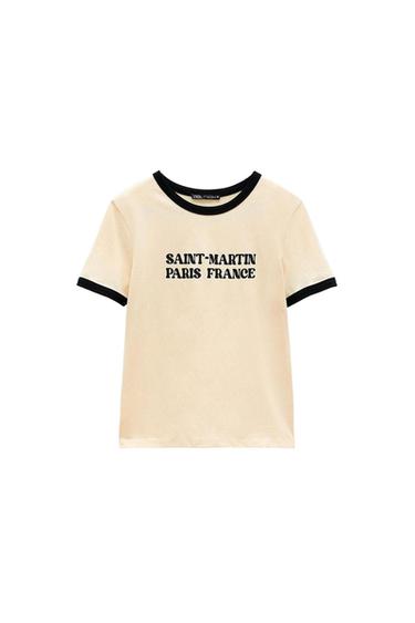 Beige short-sleeved T-shirt with black trim on the collar and sleeves. Front text: SAINT-MARTIN PARIS FRANCE. White background.