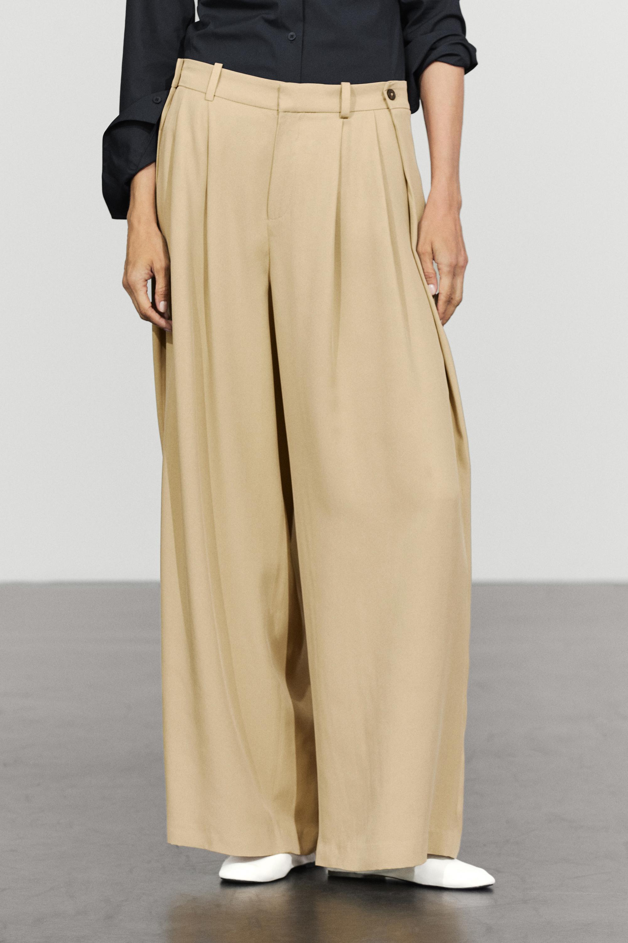 Flowing pleated pants with button detail — Beige