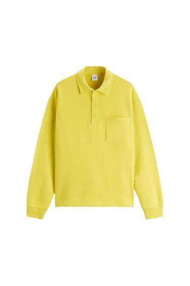 Yellow long-sleeved polo shirt with a chest pocket and button fastening. Visible inner label with the brand logo.