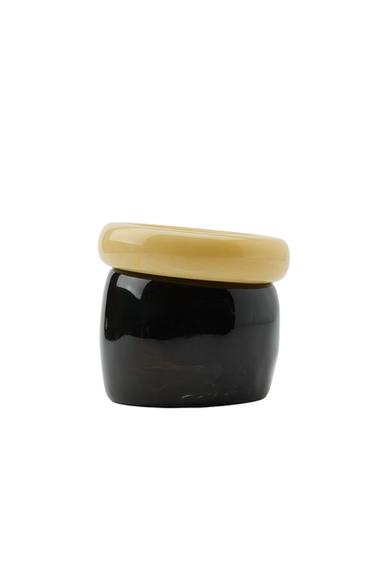 Pack of two rigid bracelets, one in ecru and one black, in different sizes.