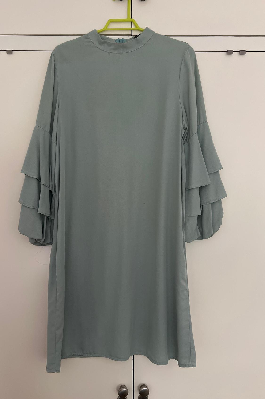 Front view of a light blue dress with frilled bell sleeves.