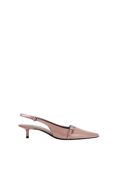 Side view of a pink low-heeled shoe with an adjustable strap and a pointed toe.