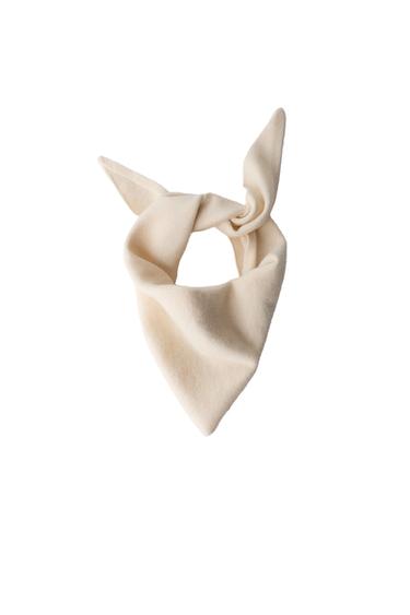 "Front view of a knitted triangular headscarf in beige."