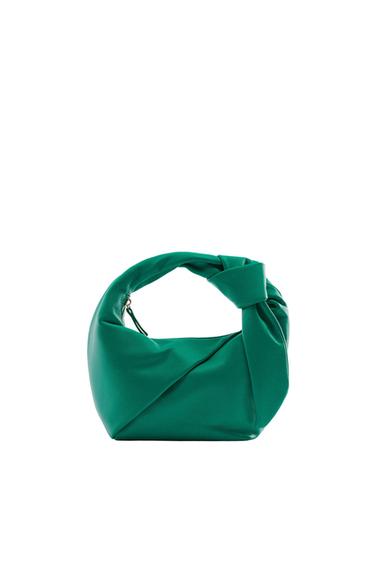 Green bag with knotted handle design on a white background.