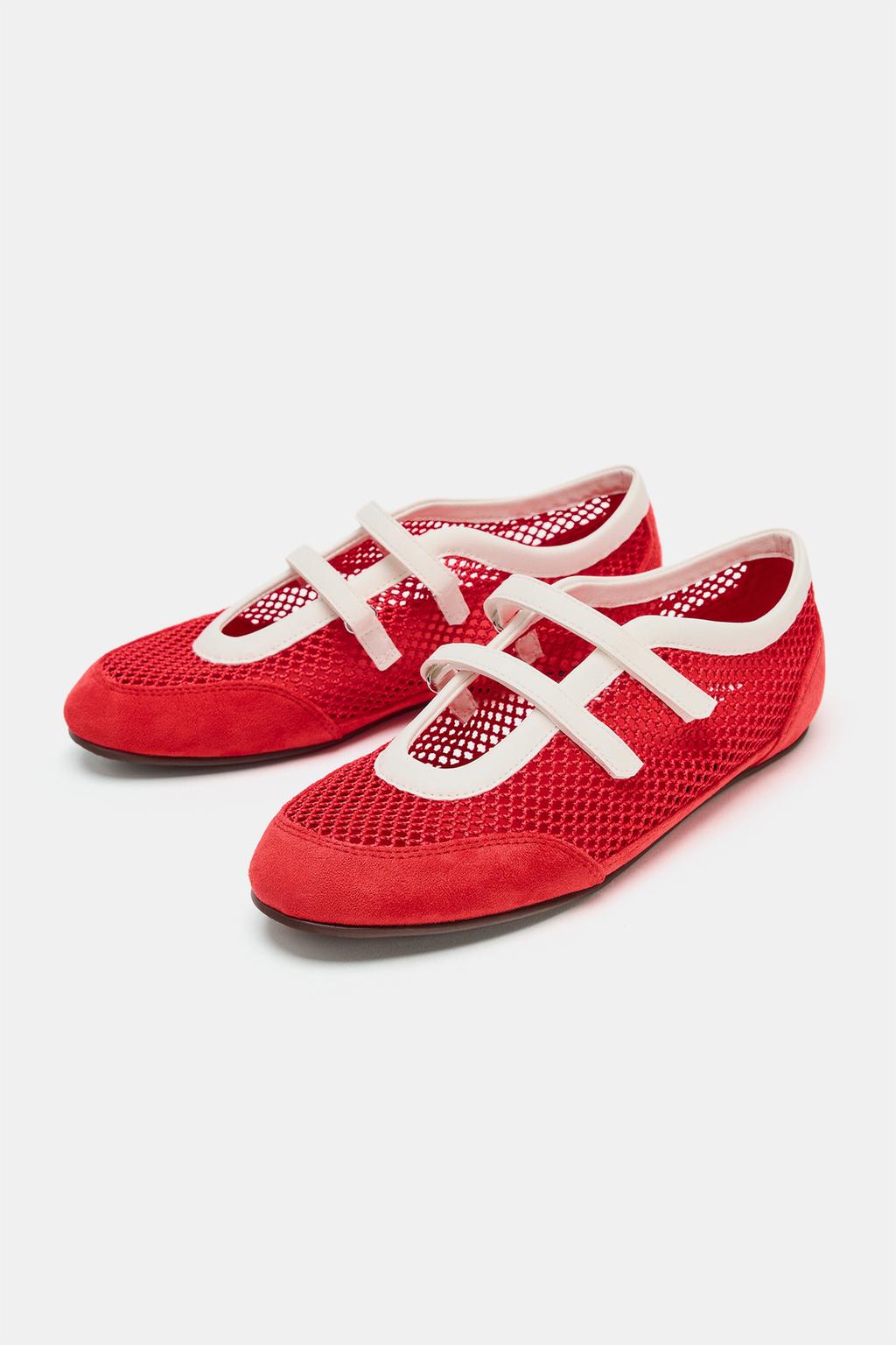 Front view of red flat shoes with a grid design, plain toe, trim, and two white straps over the instep.