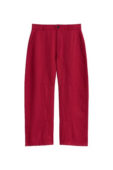 Front view of red mid-rise pants with side pockets, patch pockets on the back, and a front zip and button closure.