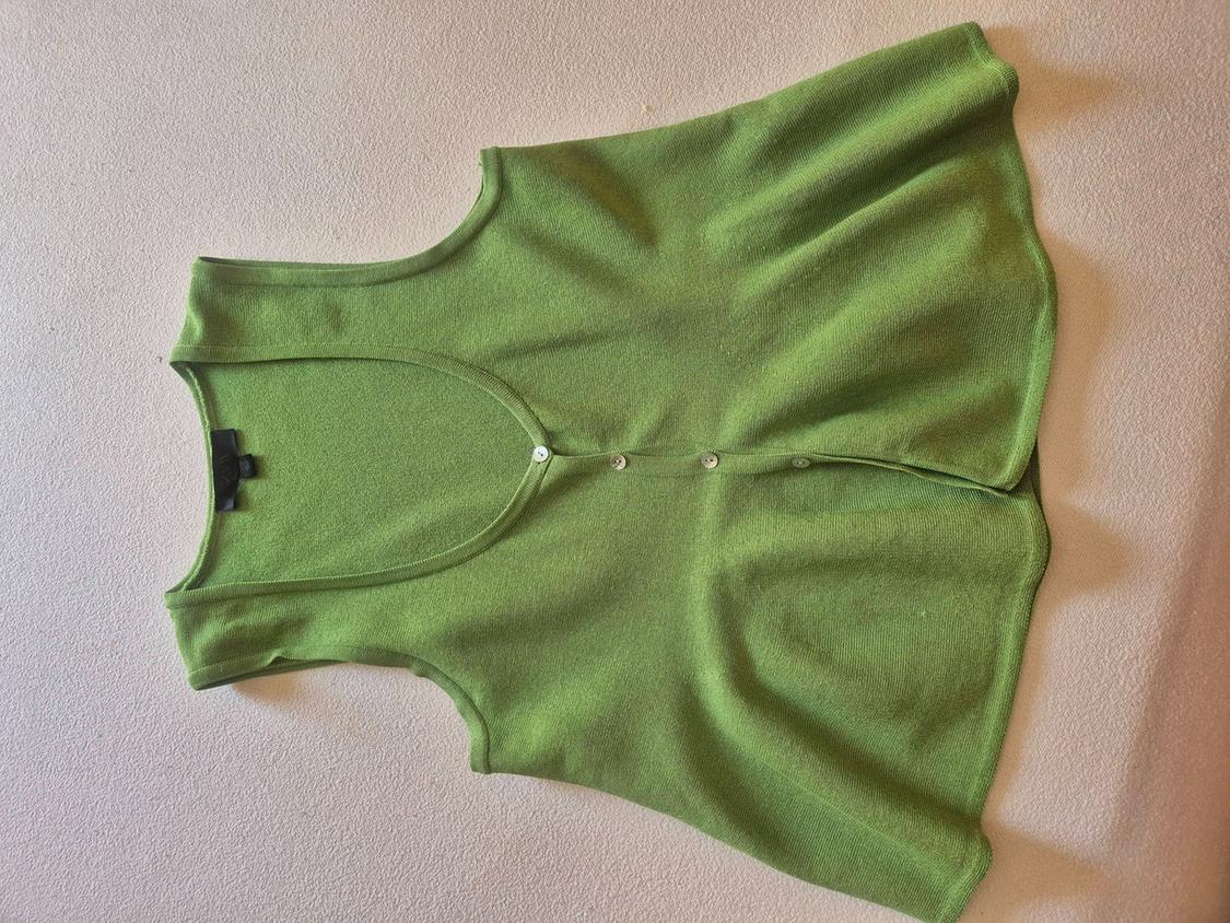 Green sleeveless knitted top, with a deep scoop neckline and buttons down the front, set against a light textured background.