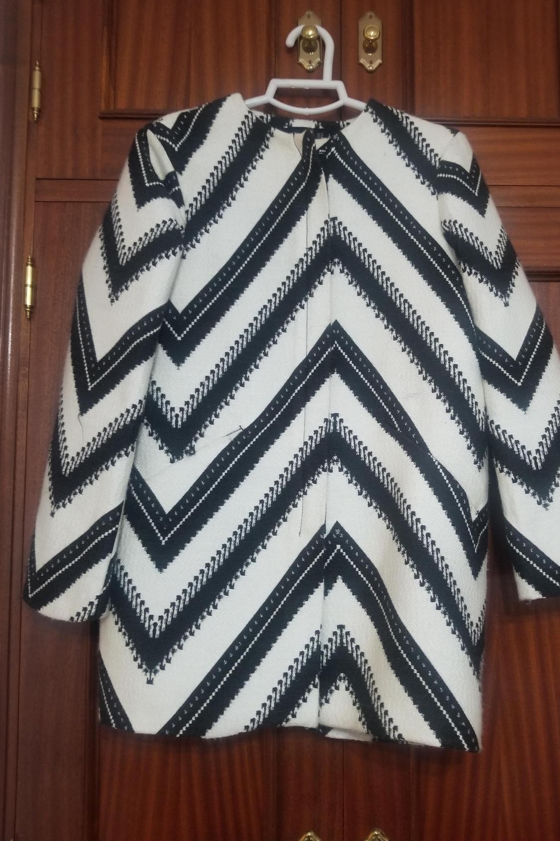 Front view of black and white coat with zigzag pattern.
