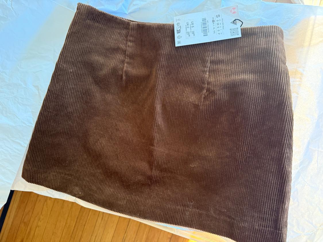 Brown corduroy skirt on white paper, with size S label visible in the top right.