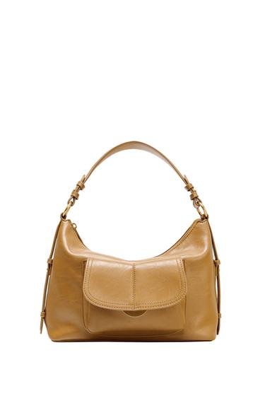 Front view of a camel-coloured handbag with flap closure and top handle.