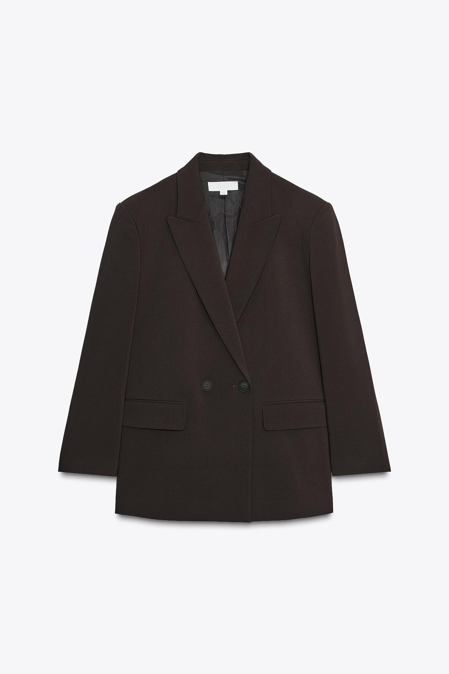 Μπροστινή όψη από oversized μαύρο σταυρωτό blazer με πέτο, μακρύ μανίκι, βάτες και μπροστινές τσέπες με καπάκι.